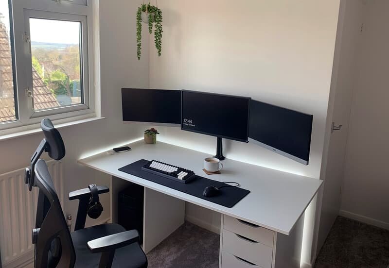 clean triple monitor black white gaming setup